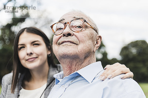 Porträt eines selbstbewussten älteren Mannes mit Enkelin im Hintergrund