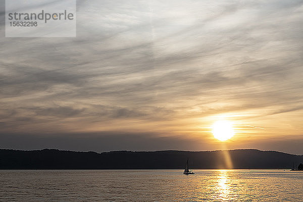 Scherenschnitt-Segelboot  das bei Sonnenuntergang auf dem Bodensee gegen den Himmel segelt  Ãœberlingen  Deutschland