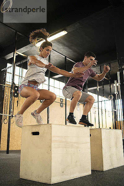 Junges Paar macht Boxsprung-Übung beim Cross-Training
