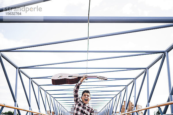 Zigeunerjunge mit Gitarre auf einer Brücke