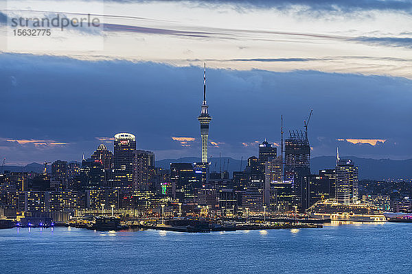 Beleuchtete moderne Gebäude am Meer gegen bewölkten Himmel in der Abenddämmerung  Ozeanien  Neuseeland