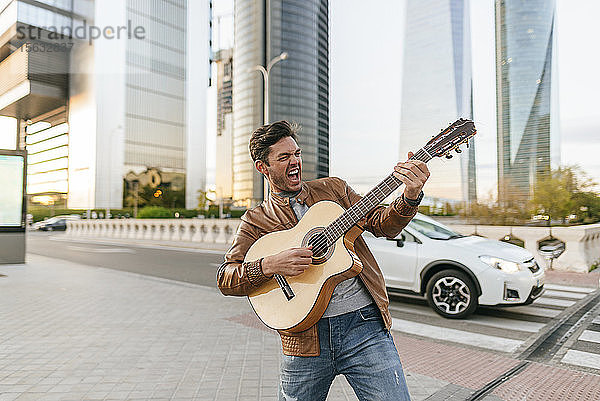 Aufgeregter Mann spielt Gitarre in der Stadt  Madrid  Spanien