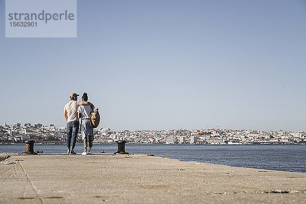 Junges Paar steht am Pier am Wasser  Lissabon  Portugal