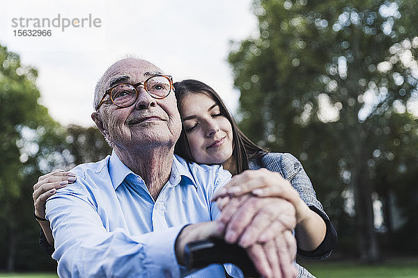 Porträt eines älteren Mannes mit seiner Enkelin in einem Park