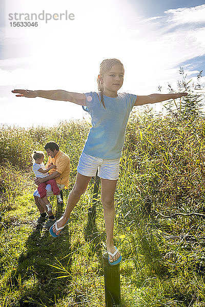 Mädchen balanciert auf einem Holzpfahl  Darss  Mecklenburg-Vorpommern  Deutschland