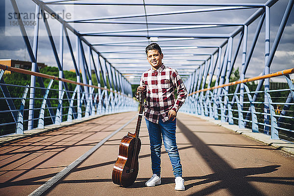 Zigeunerjunge mit Gitarre auf einer Brücke