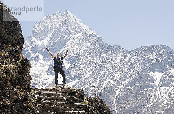 Glückliche Frau hebt die Arme vor dem Berg Thamersku  Himalaja  Solo Khumbu  Nepal