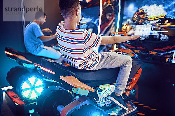 Teenager-Freunde spielen mit einem Fahrsimulator in einer Spielhalle