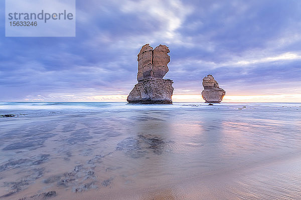 Stapel von Felsen im Meer bei Gibson Steps gegen bewölkten Himmel bei Sonnenuntergang  Victoria  Australien