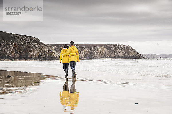 Junge Frau in gelben Regenjacken und Strandspaziergang  Bretagne  Frankreich