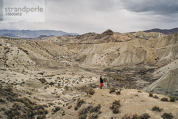 Junges Paar in Wüstenlandschaft unter bewölktem Himmel  Almeria  Andalusien  Spanien