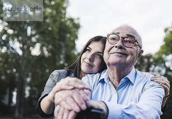 Porträt eines älteren Mannes und seiner Enkelin in einem Park