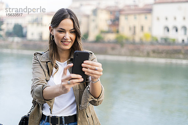 Junge brünette Frau mit Smartphone in Verona  Italien
