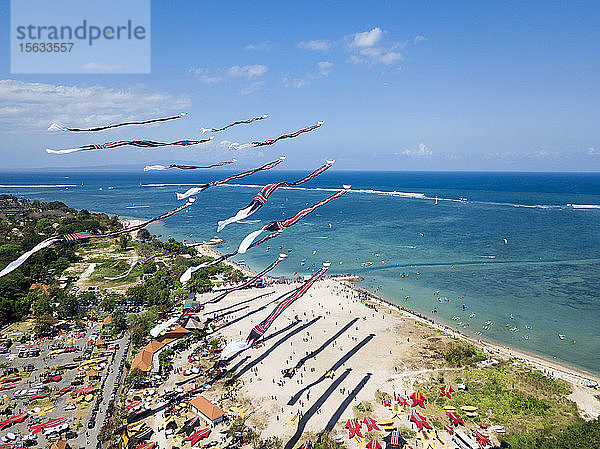 Drohnenschuss von über den Strand fliegenden Drachen gegen blauen Himmel während des Festivals in Bali  Indonesien