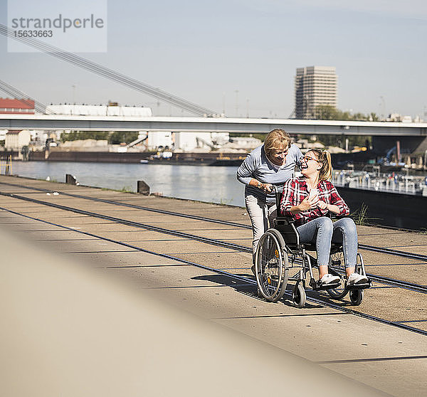 Großmutter mit ihrer Enkelin im Rollstuhl sitzend