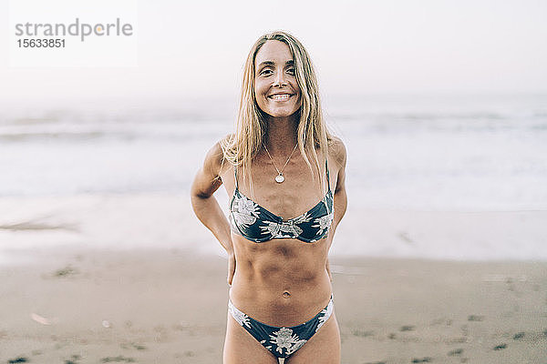 Junge blonde Frau im Bikini am Strand