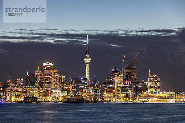Beleuchtete moderne Gebäude am Meer gegen bewölkten Himmel in der Abenddämmerung in Ozeanien  Neuseeland
