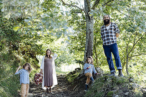 Porträt einer glücklichen Familie mit zwei Kindern im Wald