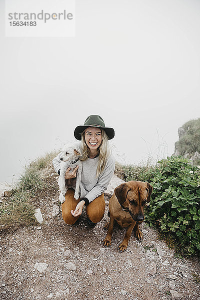 Junge Frau mit zwei Hunden auf dem Aussichtspunkt