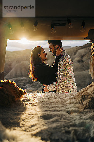 Glückliches junges Paar auf einer Reise mit einem Wohnmobil bei Sonnenuntergang  Almeria  Andalusien  Spanien