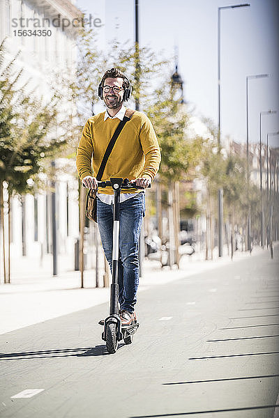 Junger Mann fährt E-Scooter in der Stadt
