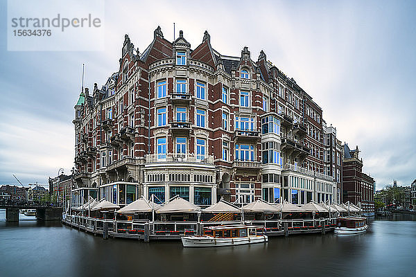 Niederlande  Amsterdam  Vordächer von Cafés  die Gebäude am Wasser umgeben
