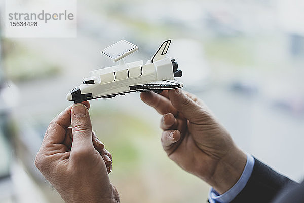 Nahaufnahme eines Geschäftsmannes mit einem Space-Shuttle-Modell