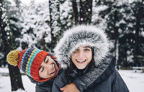 Porträt eines glücklichen jungen Paares im Winterwald