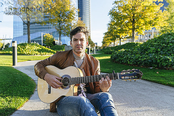 Mann spielt Gitarre in einem städtischen Park  Madrid  Spanien