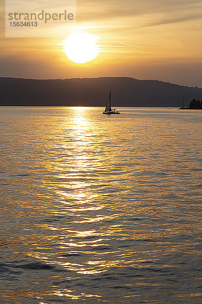 Scherenschnitt-Segelboot segelt auf dem Bodensee gegen den Himmel bei Sonnenuntergang in Ãœberlingen  Deutschland