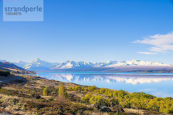 Neuseeland  Südinsel  Landschaftliche Ansicht des Ufers des Pukaki-Sees mit schneebedeckten Bergen im Hintergrund