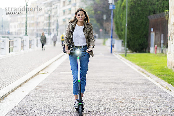 Junge Frau mit E-Scooter in Verona  Italien