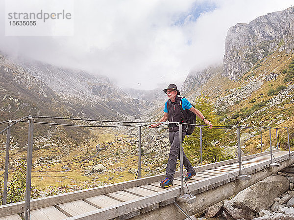 Wanderer  der über einen Steg in den Bergen geht  Naturpark Adamello  Italien