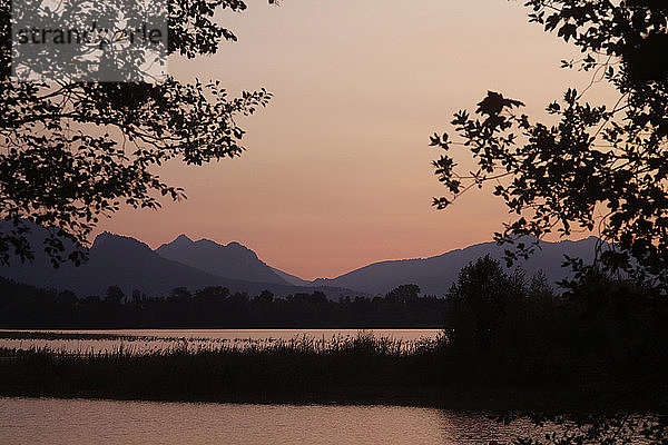 Landschaftlicher Blick auf den Forggensee und die Silhouette der Berge gegen den klaren Himmel bei Sonnenuntergang unter OstallgÃ¤u  Deutschland