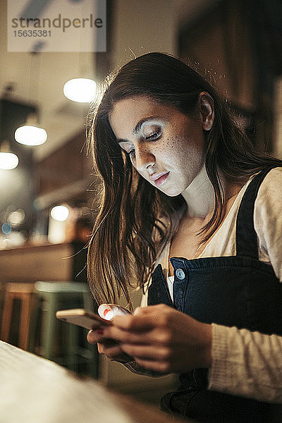 Frau benutzt ihr Smartphone in einem Café