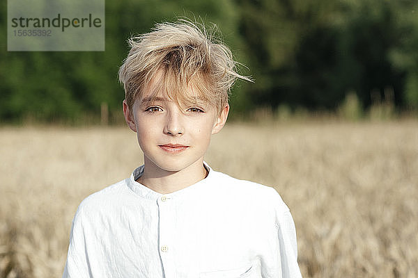 Bildnis eines blonden Jungen in einem Haferfeld