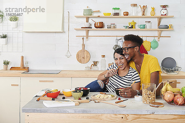 Multiethnisches Paar frühstückt gemeinsam in der Küche