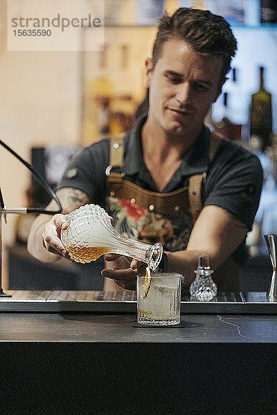 Barkeeper mixt Cocktail in einer Bar  Dekanter mit Dampf