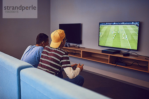 Teenager-Freunde spielen Videospiel in einer Spielhalle