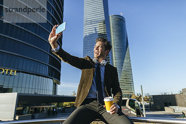 Glücklicher Geschäftsmann nimmt ein Selfie im städtischen Geschäftsviertel  Madrid  Spanien