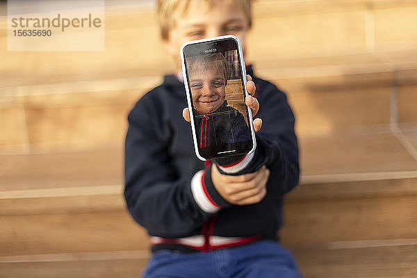 Display eines Mobiltelefons mit lächelndem kleinen Jungen  Nahaufnahme