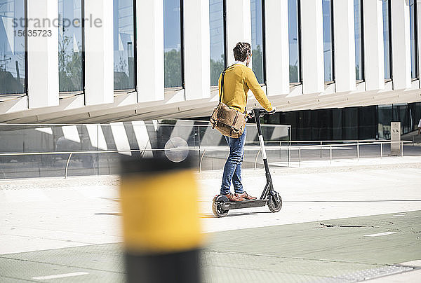 Junger Mann fährt E-Scooter in der Stadt