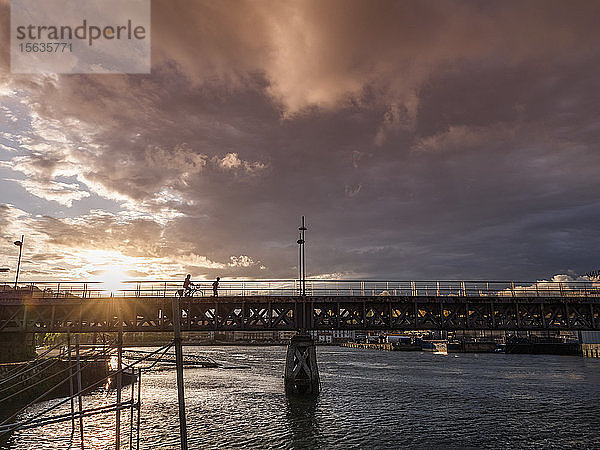 Scherenschnittbrücke über den Fluss vor bewölktem Himmel bei Sonnenuntergang  Zumaia  Spanien