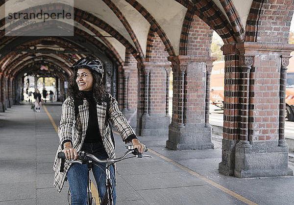 Glückliche Fahrrad fahrende Frau in der Stadt  Berlin  Deutschland