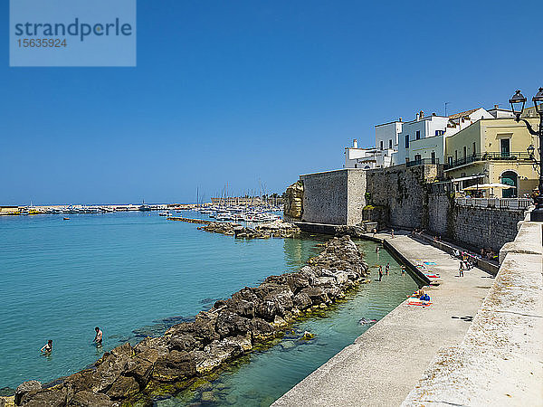 Italien  Provinz Lecce  Otranto  Menschen  die sich im Sommer am Ufer einer Küstenstadt entspannen