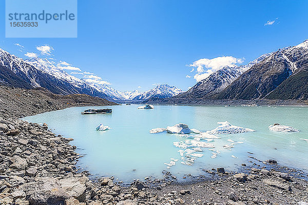 Neuseeland  Südinsel  felsiges Ufer des Tasman Lake mit Eisbergen  Gletscher und Bergkulisse
