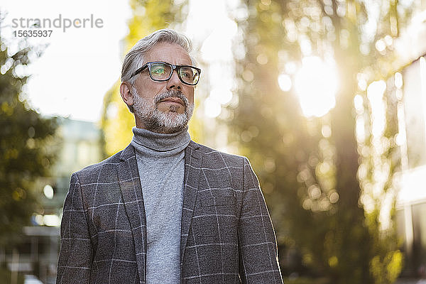Porträt eines modischen  reifen Geschäftsmannes mit Brille im Freien