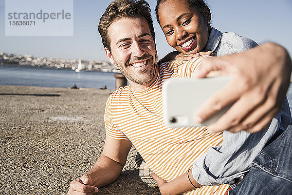 Glückliches junges Paar beim Selfie am Pier am Wasser  Lissabon  Portugal