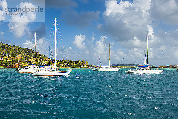 Segelboot vor der Insel Union vor Anker vor bewölktem Himmel  Grenadinen  St. Vincent und die Grenadinen  Karibik