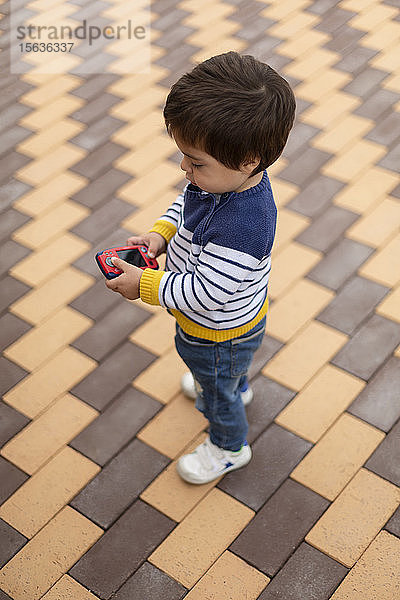 Kleiner Junge spielt mit Spielzeug-Handy
